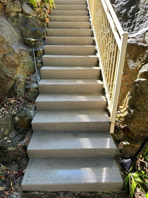 Exterior stairs resurfaced along a rock retaining wall