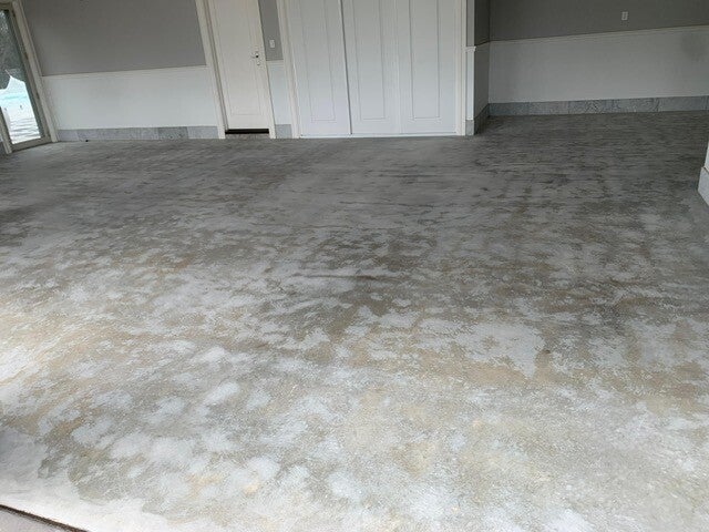 Concrete floor showing patchy residue before preparation