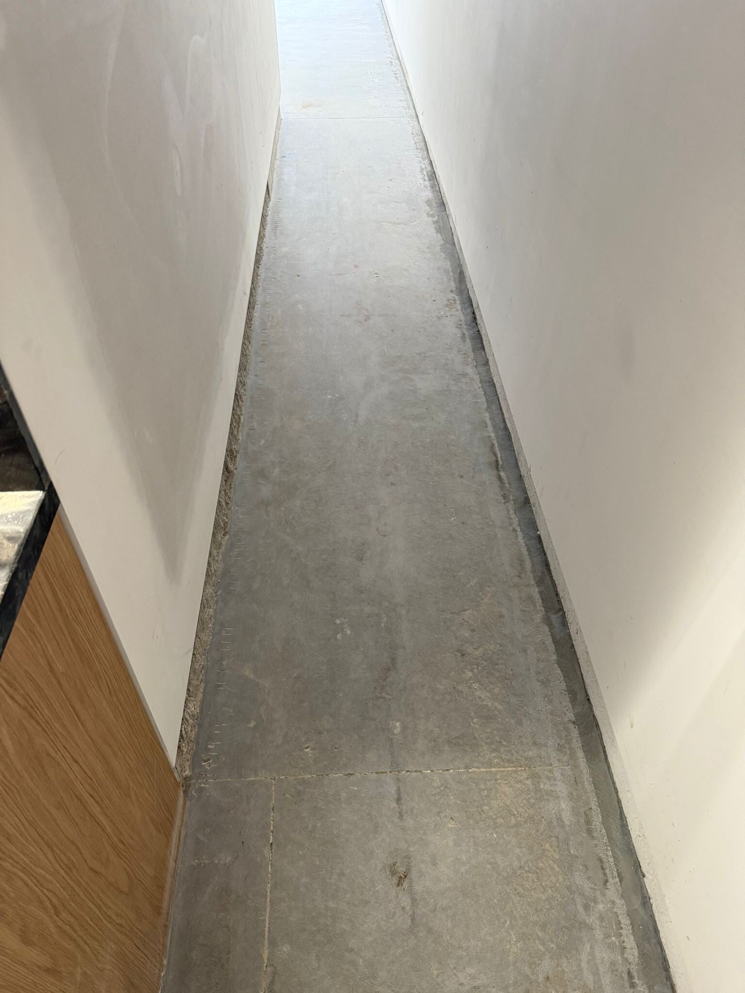 Resurfaced concrete pathway between two walls