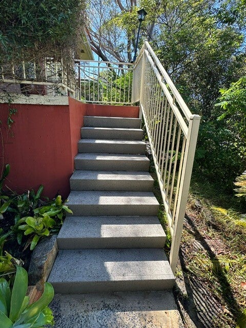 Resurfaced stairs beside a rendered feature wall